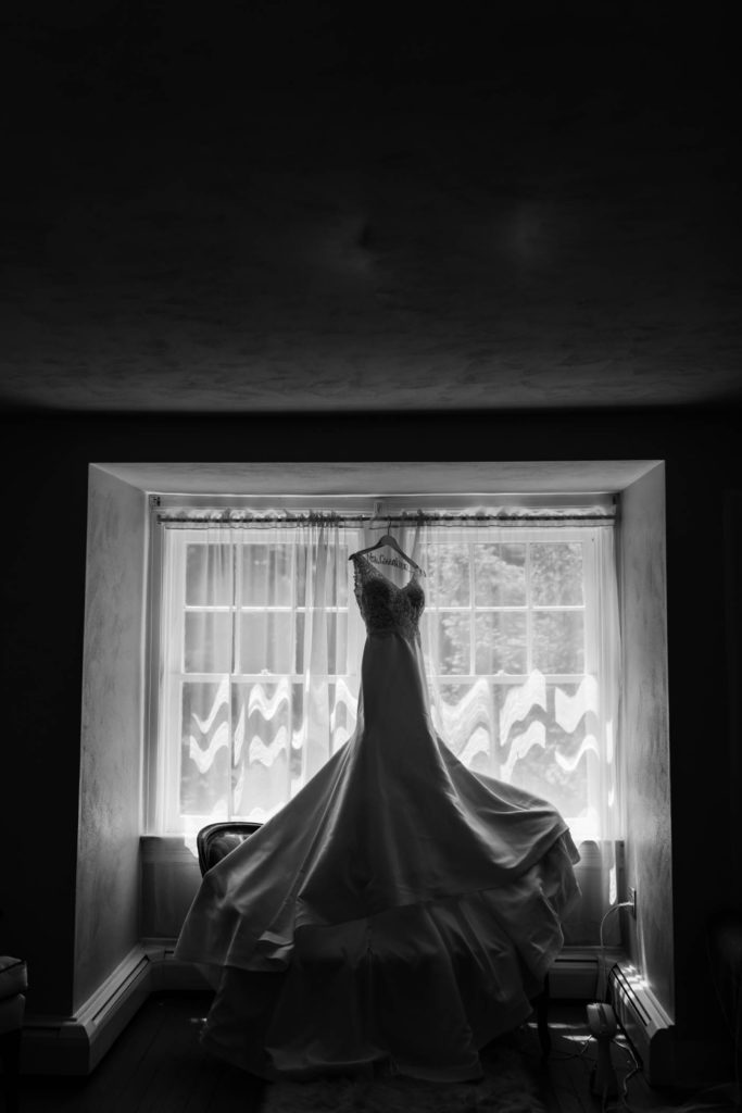 bride dress hanging in window 