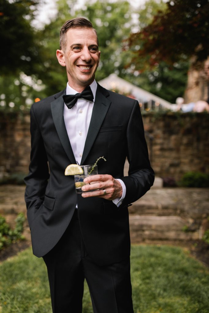 groom posing for photo with cocktail