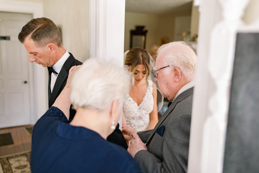 grandparents pray over bride and groom 