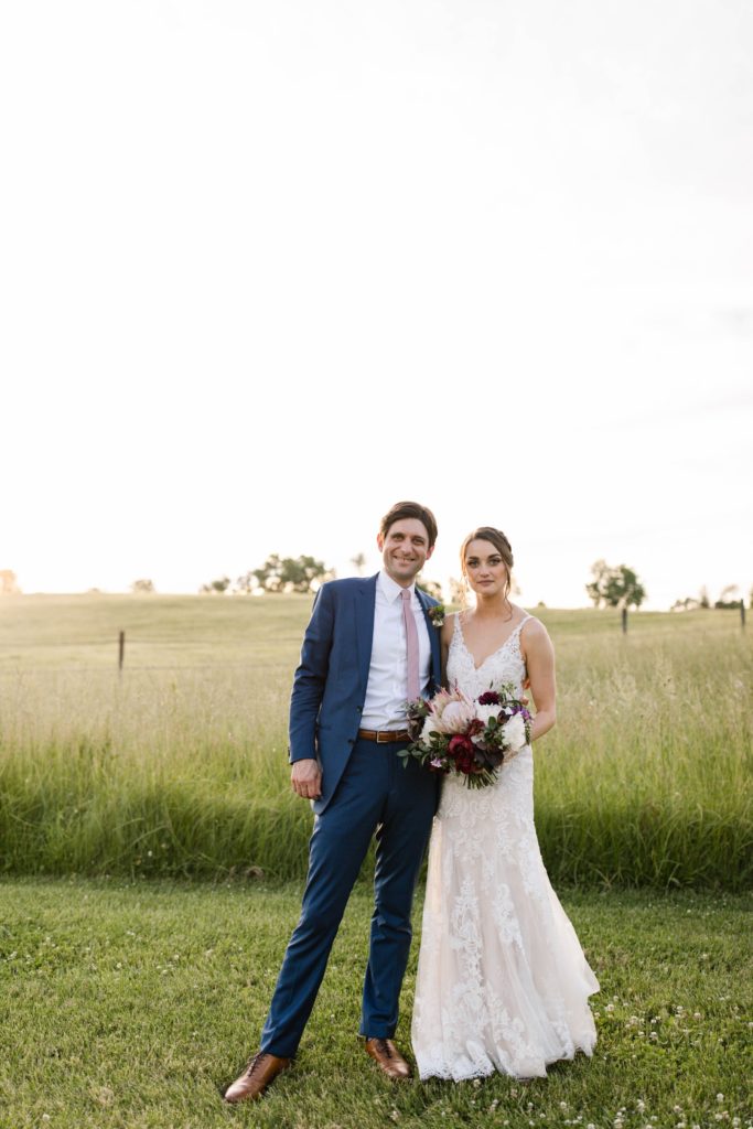 couple posing in field at wedding at esser estate