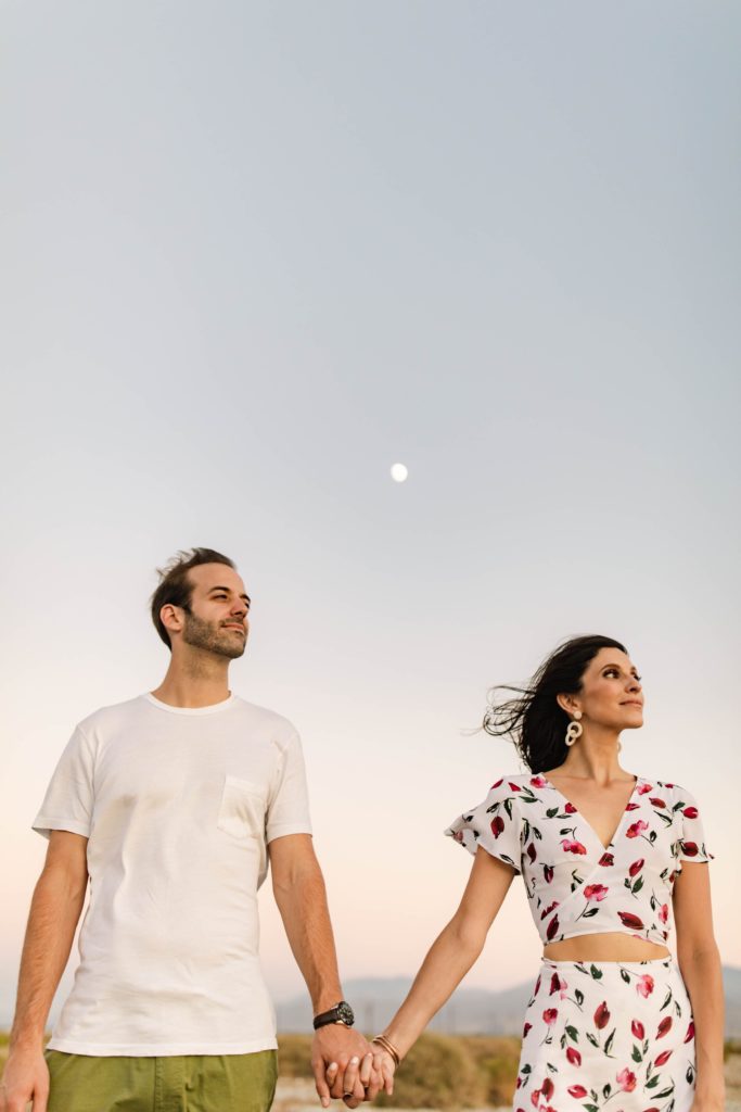 couple pose by moon in desert in palm springs