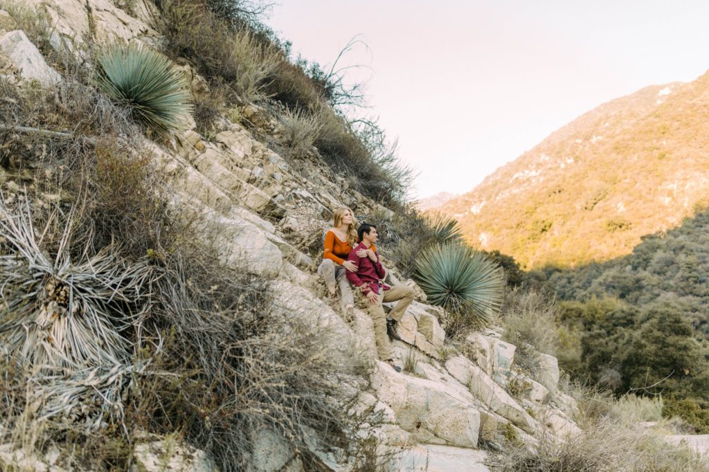 couple sitting on rocks looking at over in angeles national forest 