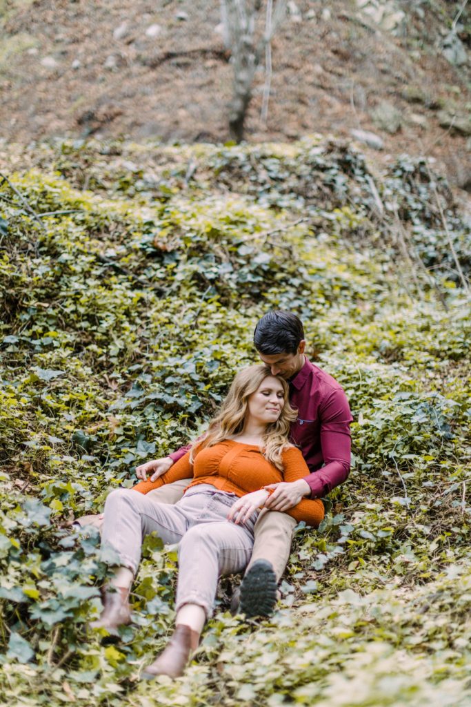 couple sitting in ivy for engagement session 