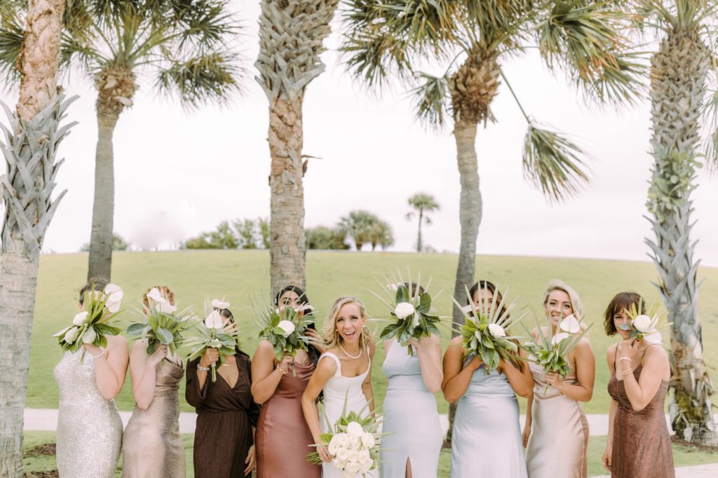 bridesmaids holding flowers over face
