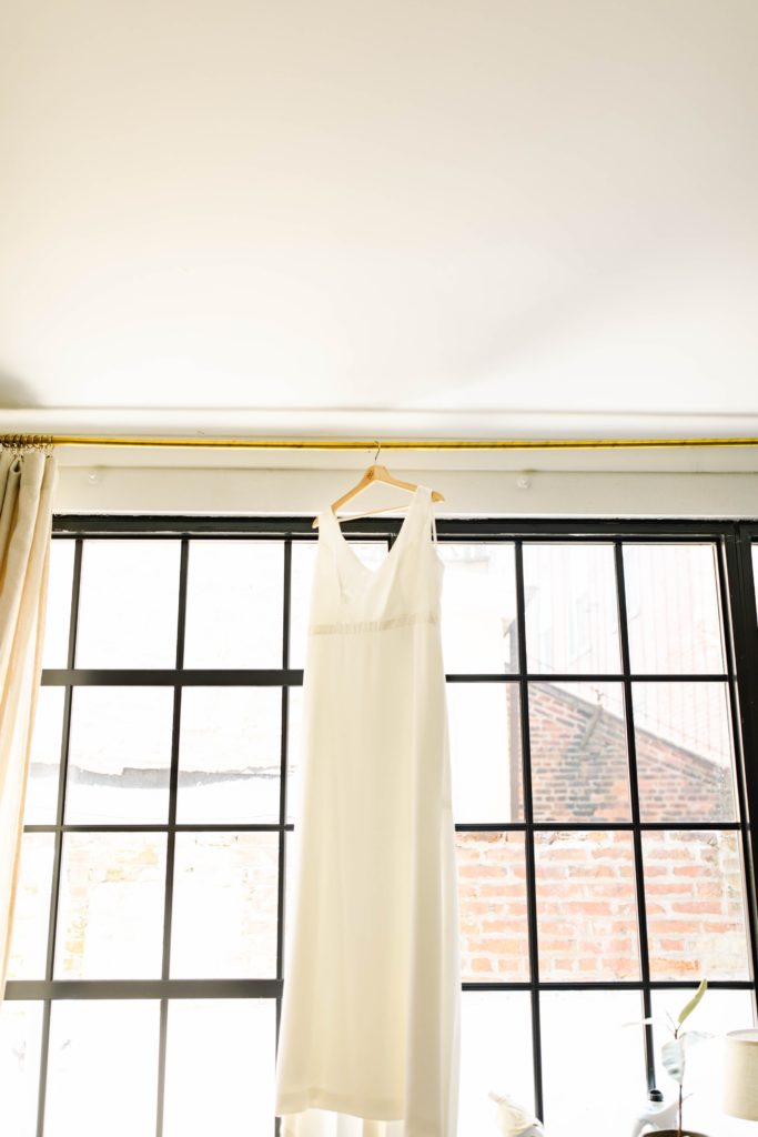 brides dress hanging in window