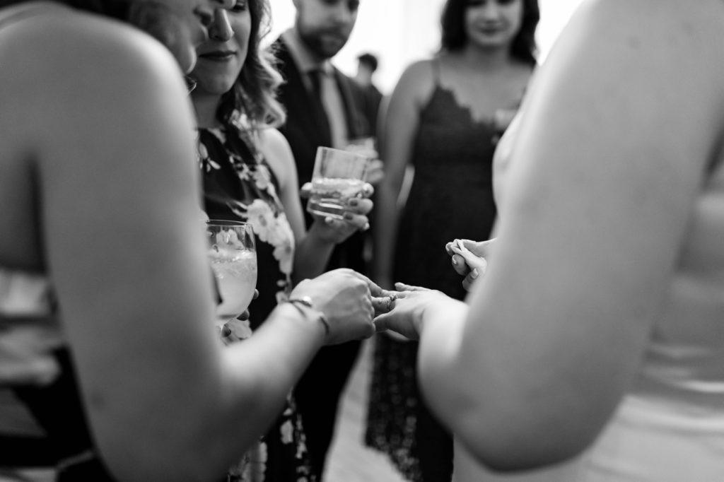 people checking out brides ring at cocktail hour