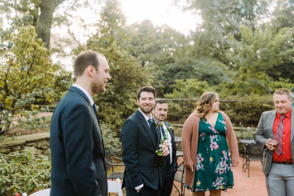 groom laughing with friends at cocktail hour 