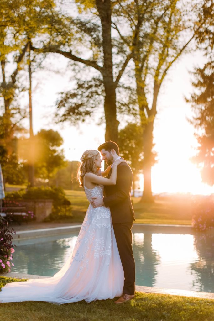 bride and groom snuggle in sunset 