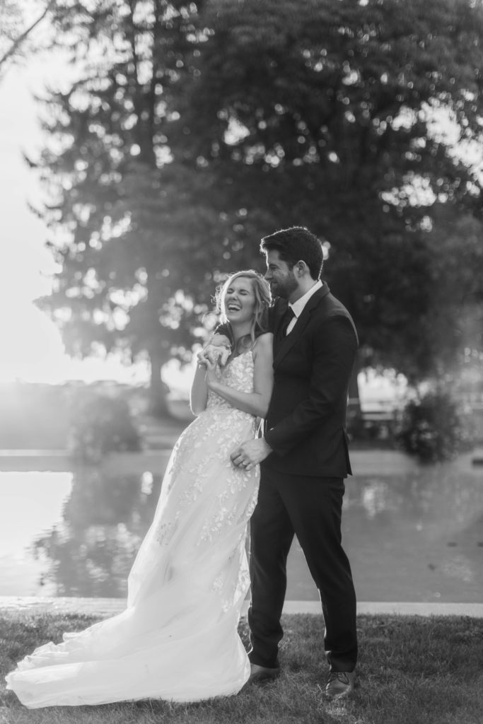 bride and groom laugh in sunset 