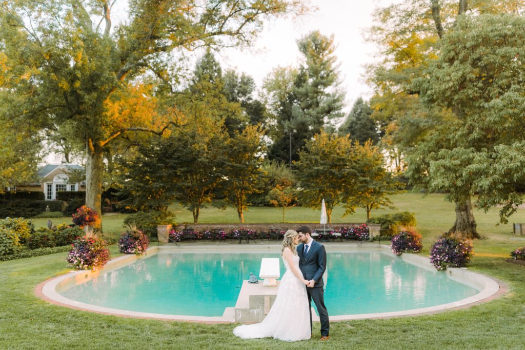 bride and groom in front of pool 