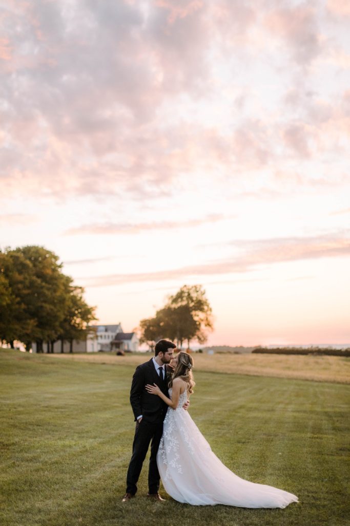 bride and groom kiss in sunset 