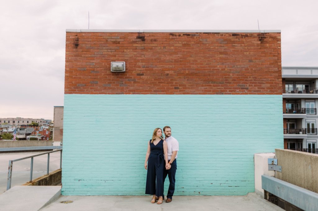 couple posing in front of colorful wall