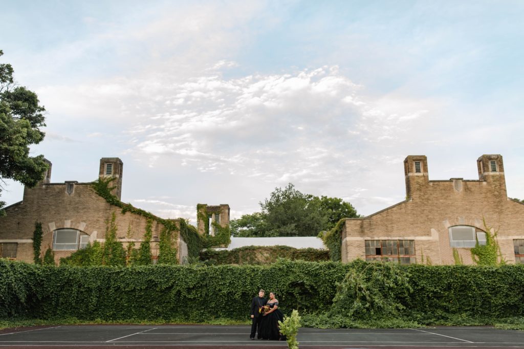 couple posing for anniversary session in abandoned tennis court