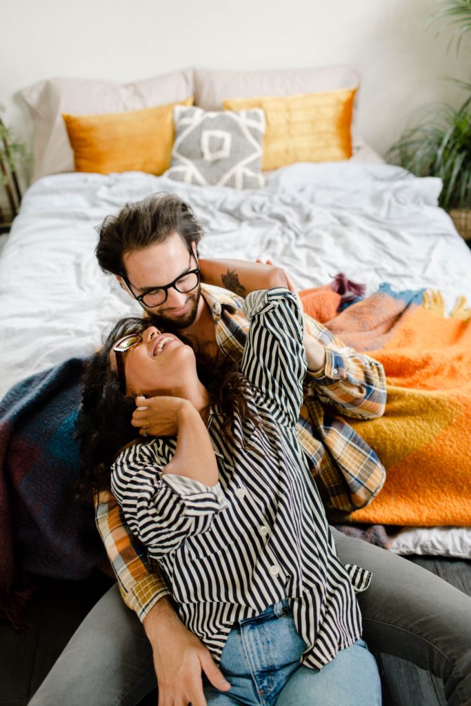 couple snuggling on floor during steamy in home session