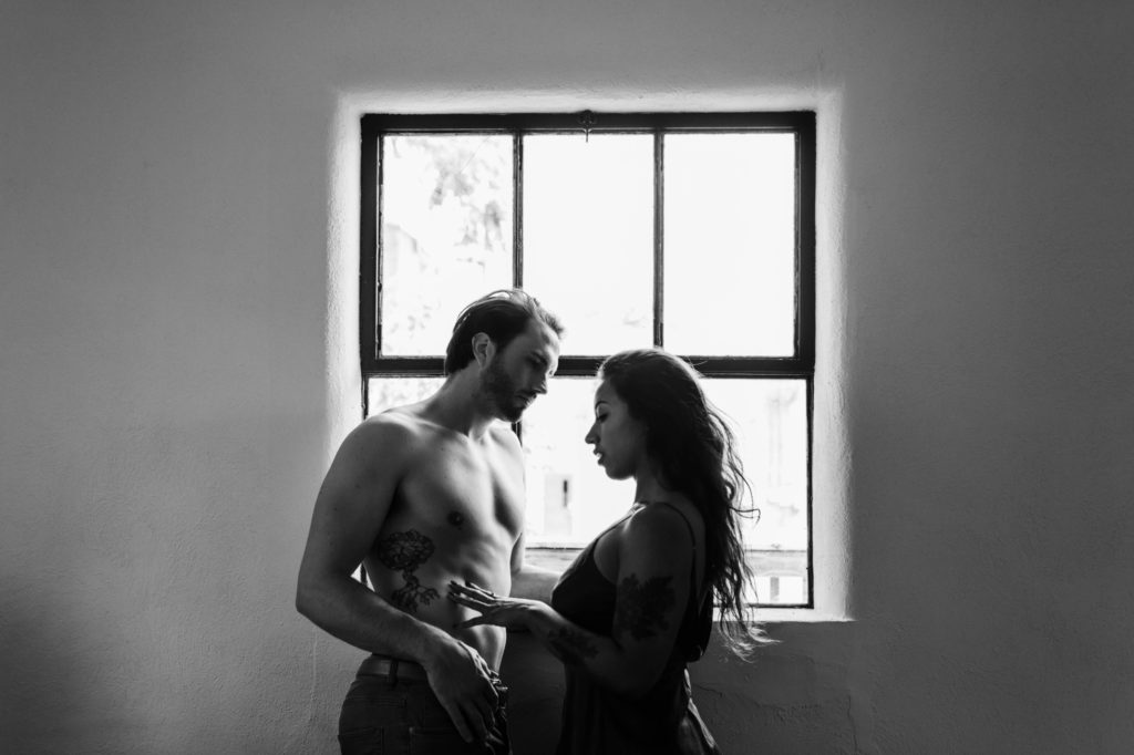 sexy couple against wall during in home session 