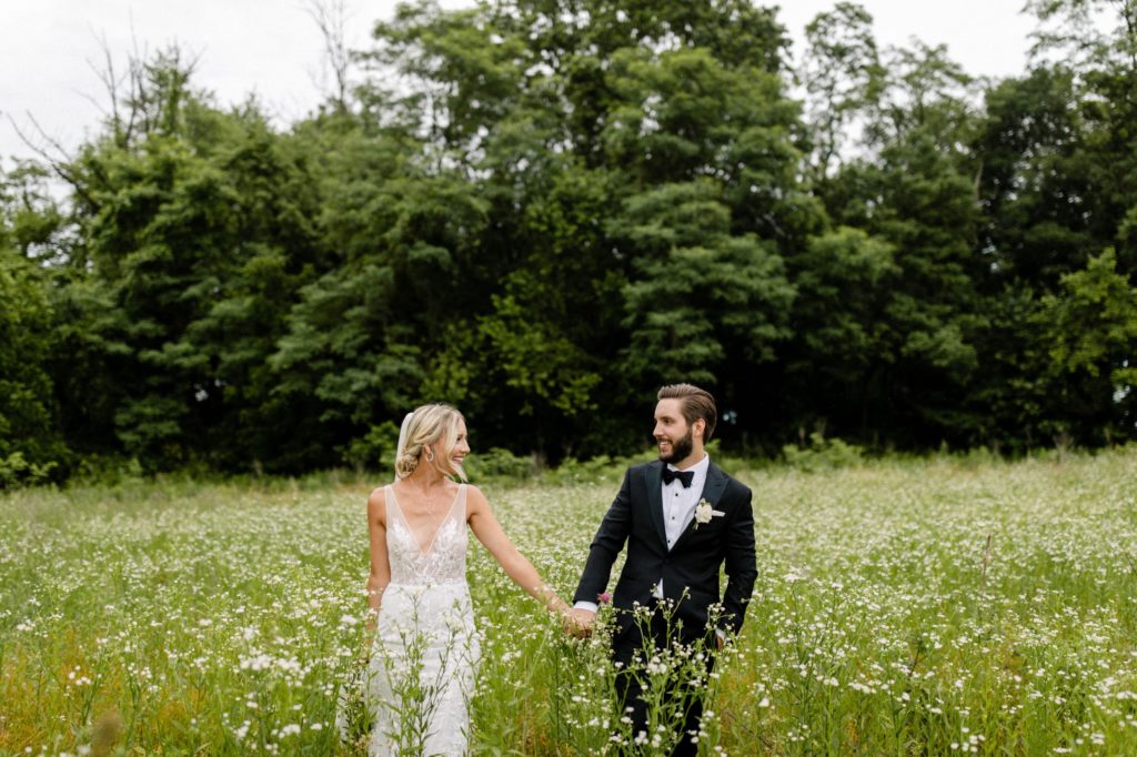 couple poses for wedding photos in flower field