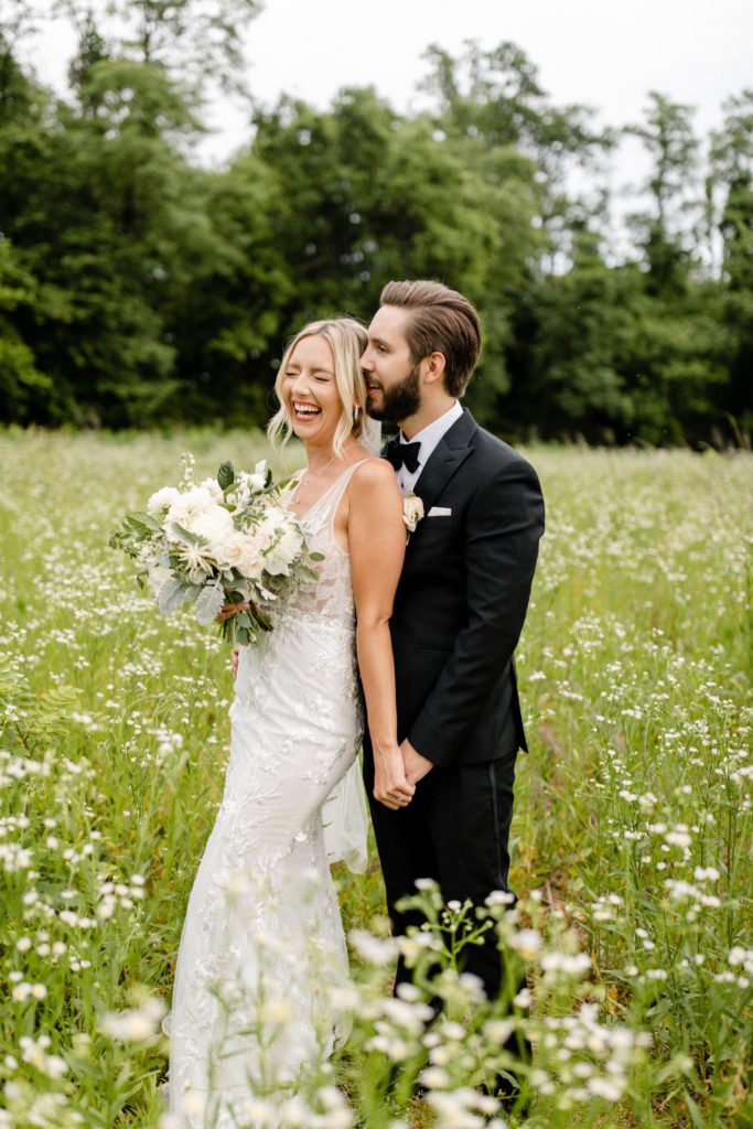 couple poses for wedding photos in flower field