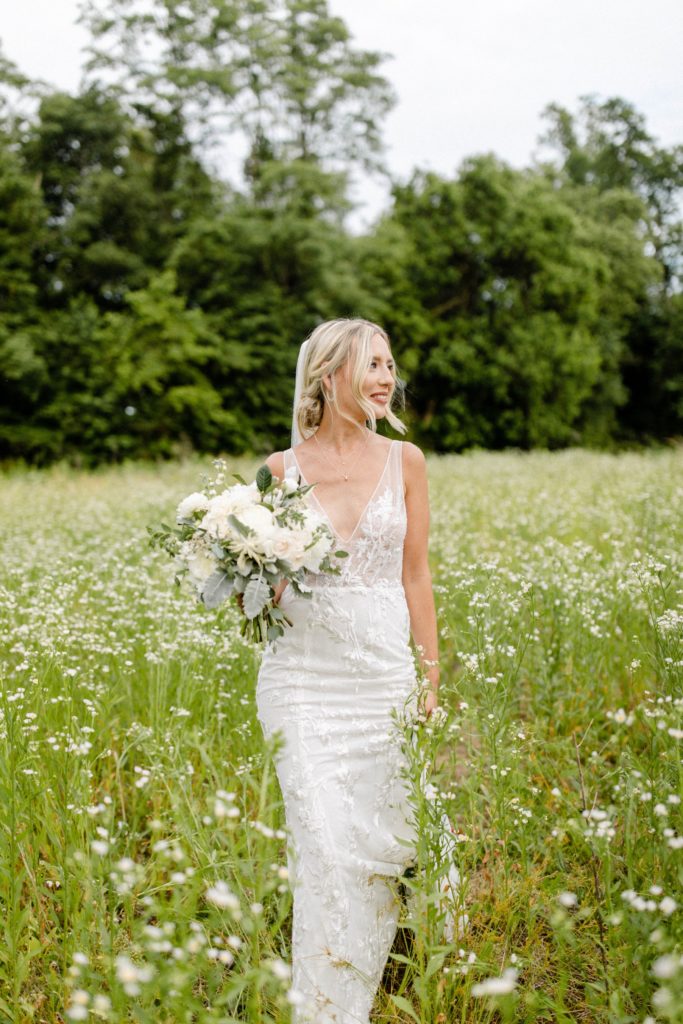 bride poses in flower field for wedding photos