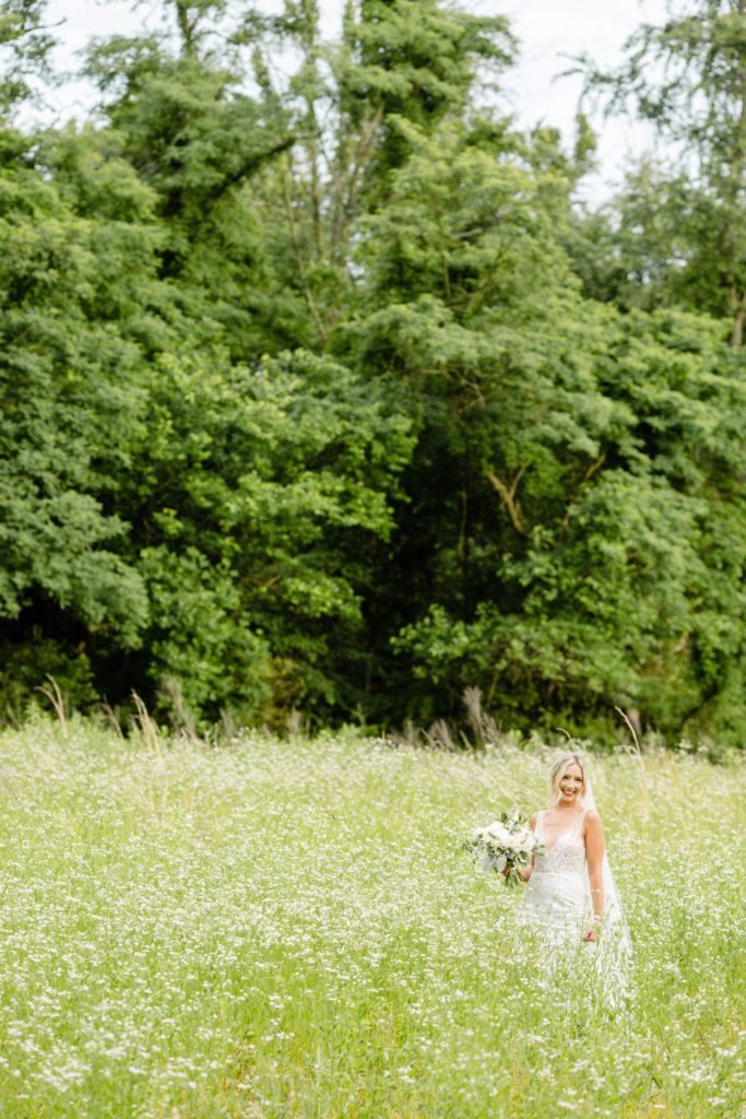 bride poses for wedding photos in flower field