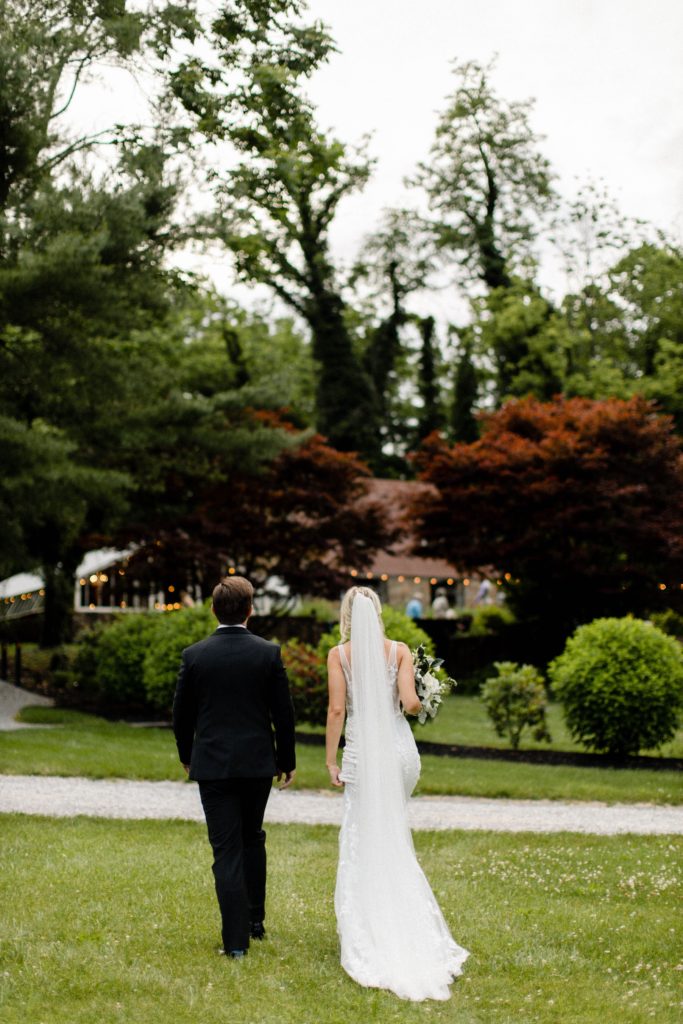 couple walking on grass at intimate wedding