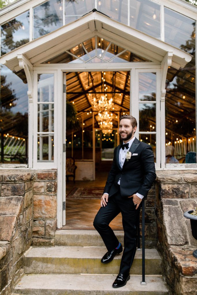 groom poses for portraits at intimate wedding