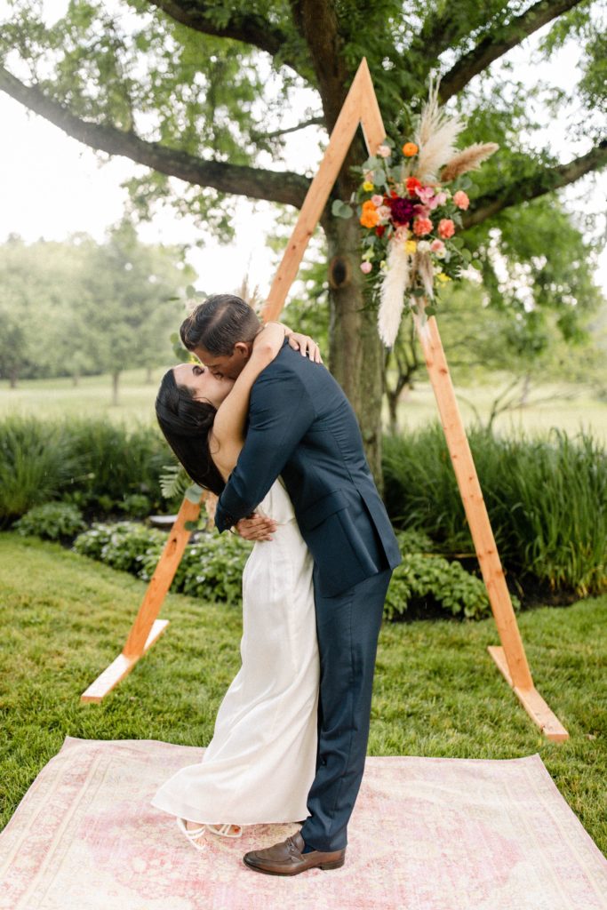 couple kissing at backyard wedding