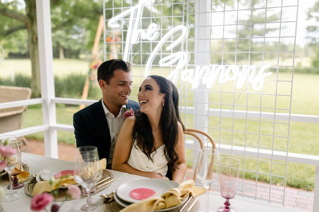 couple laughing sitting at head table