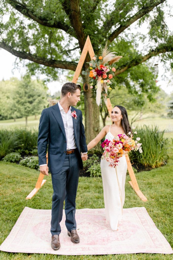 couple standing in front of ceremony arch at intimate wedding