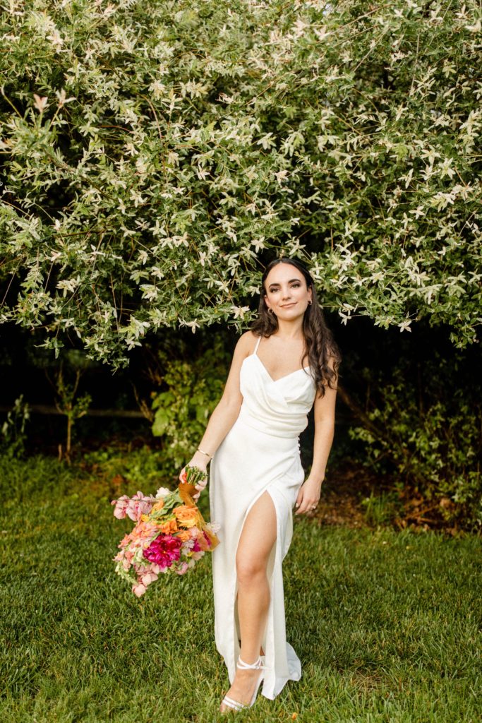 bride posing for intimate backyard wedding holding bouquet