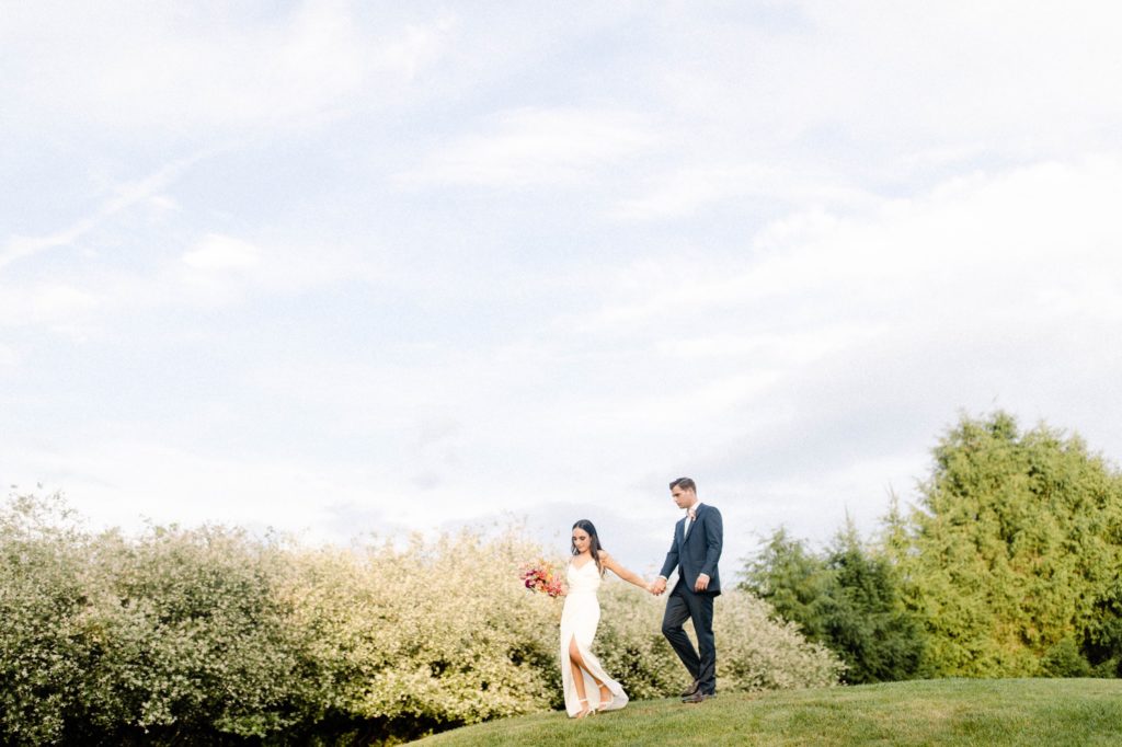 couple walking down hill at intimate wedding