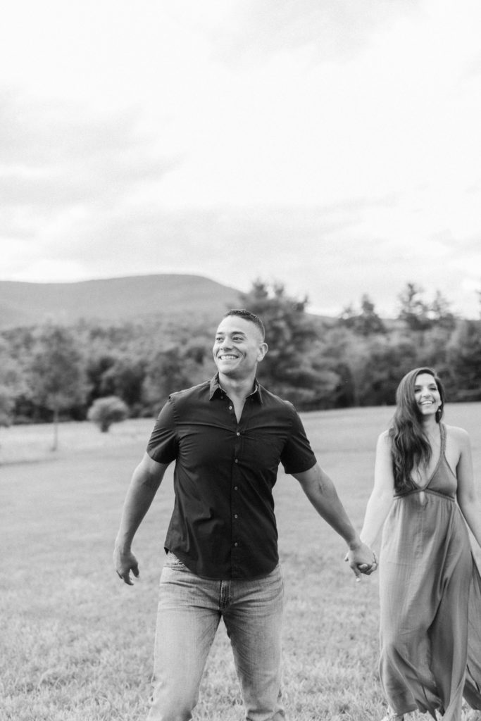 couple laughing in field for engagement session in woodstock