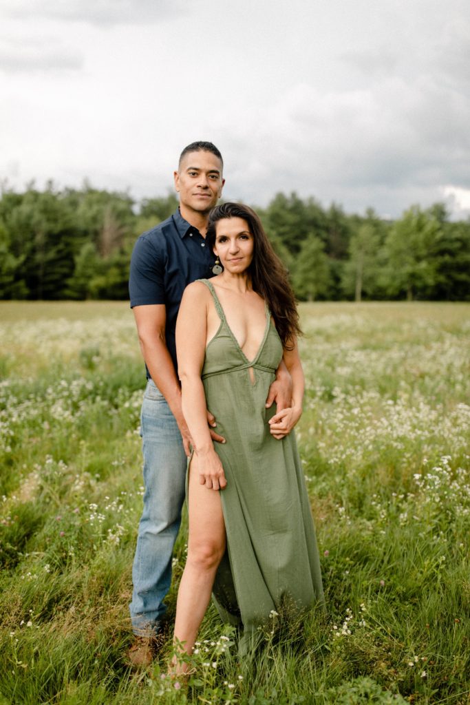 couple posing for woodstock engagement session in field