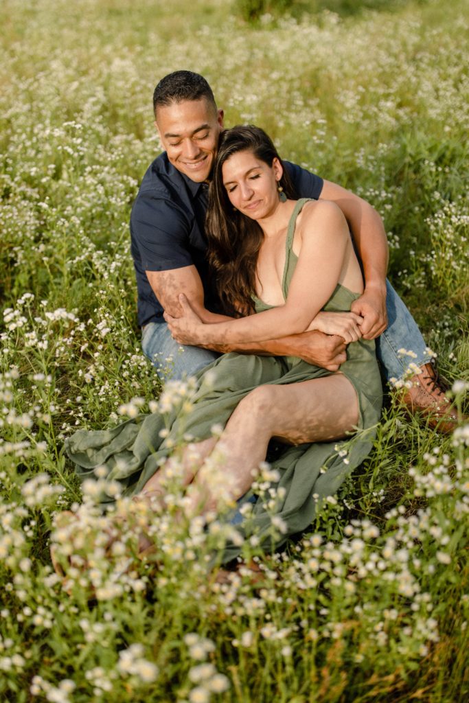 couple laying in flower field for woodstock engagement session