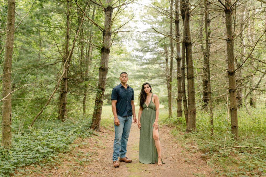 couple posing in pine trees for woodstock engagement session