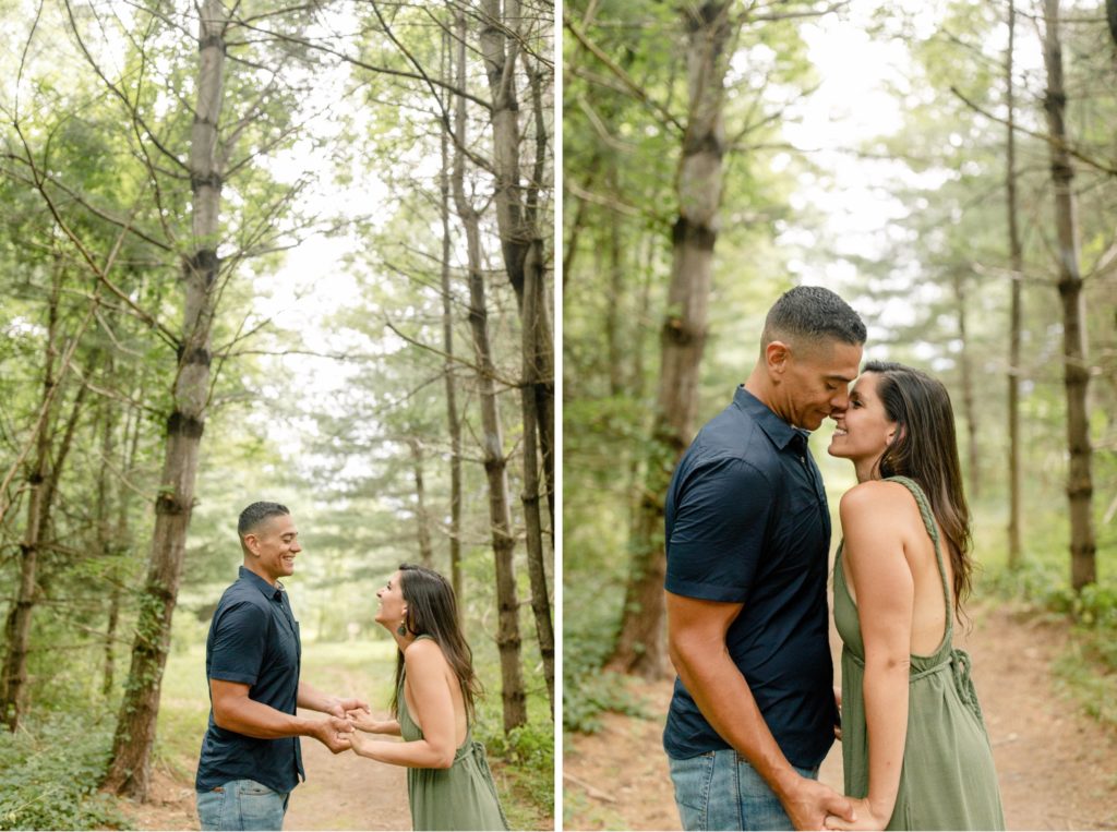 couple kissing in pine trees for woodstock engagement session
