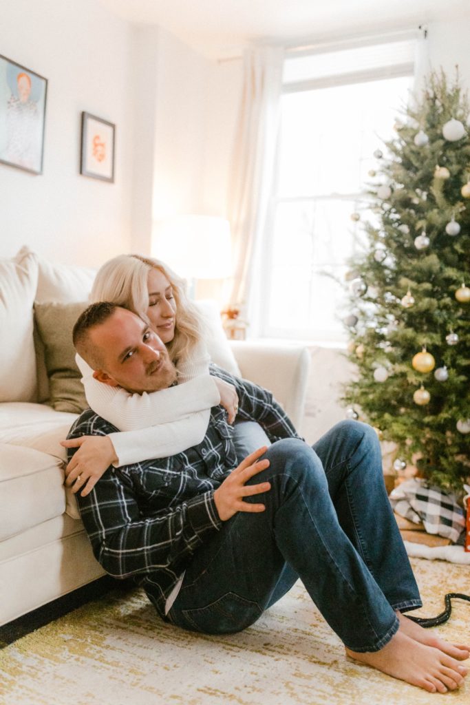 couple snuggling in their home for in home engagement session