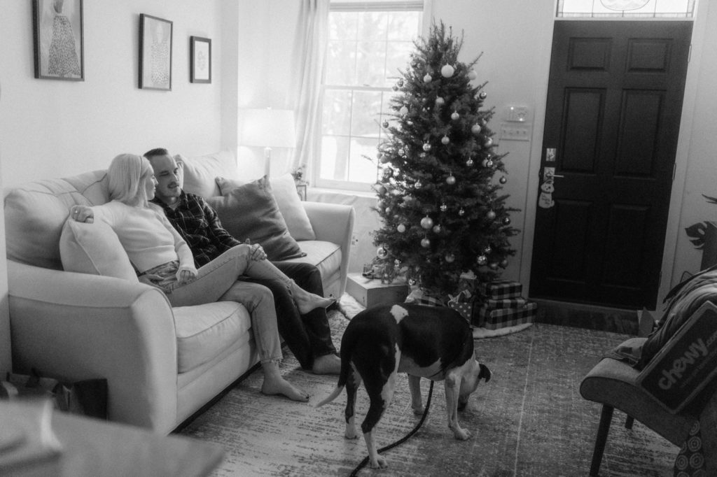 a couple and their dog chilling on couch at in home engagement session 
