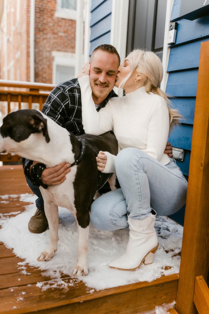 a couple posing with their dog for their winter engagement session 