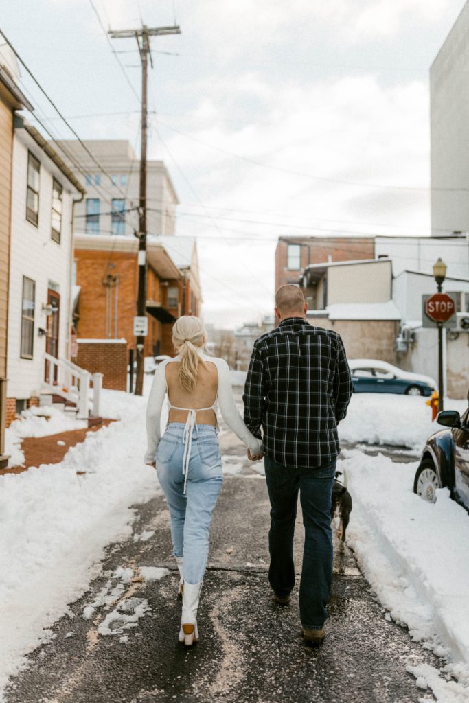 a couple walking down a snow covered street 