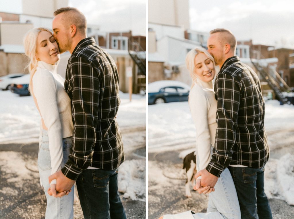 a couple snuggling on snow covered street for winter engagement session 