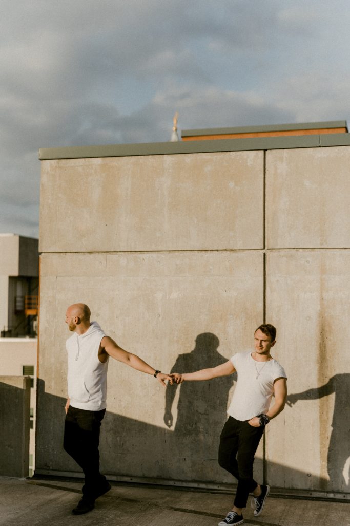 a couple standing on top of a parking garage holding hands 