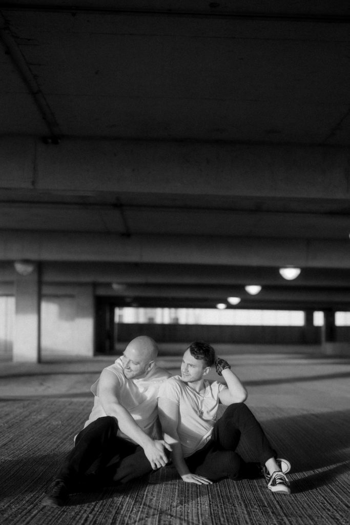 a couple sitting in the sun on a parking garage