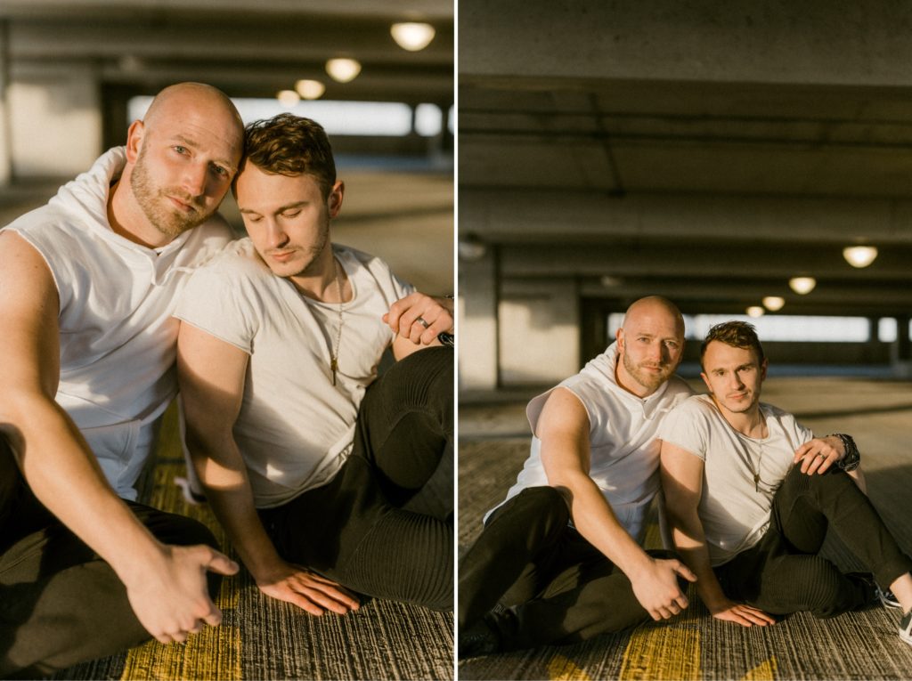 a couple posing on the floor of a parking garage