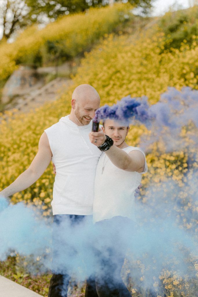 a couple laughing holding smoke bombs