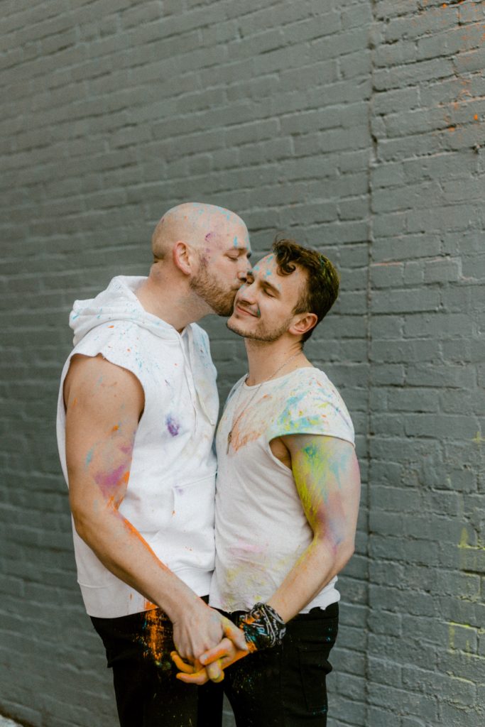 a couple kissing while covered in paint
