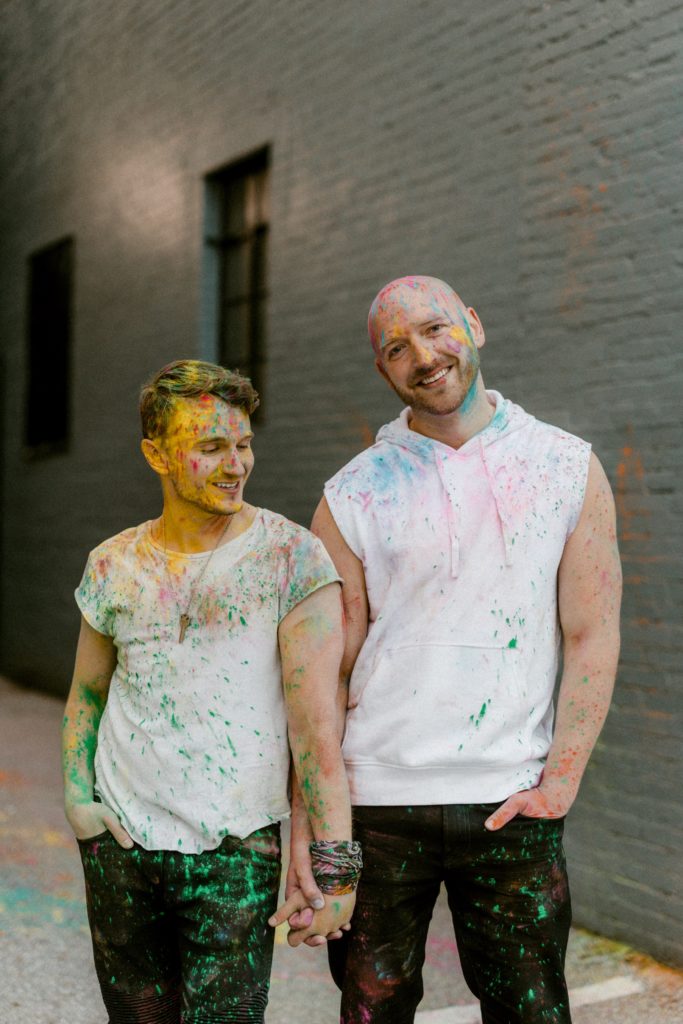 a couple pose for photo session covered in paint