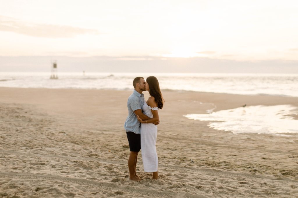 couple kissing on beach at sunrise for sunrise rehoboth beach engagement session