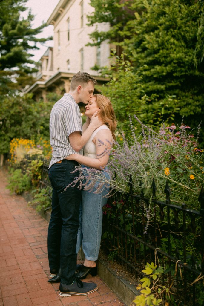 couple kissing on sidewalk in the flowers for romantic philadelphia couples session