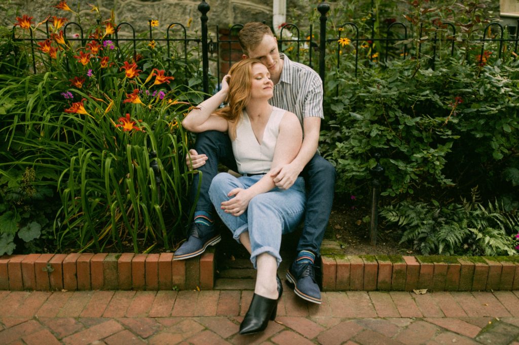 couple sitting on steps in flowers in philadelphia 