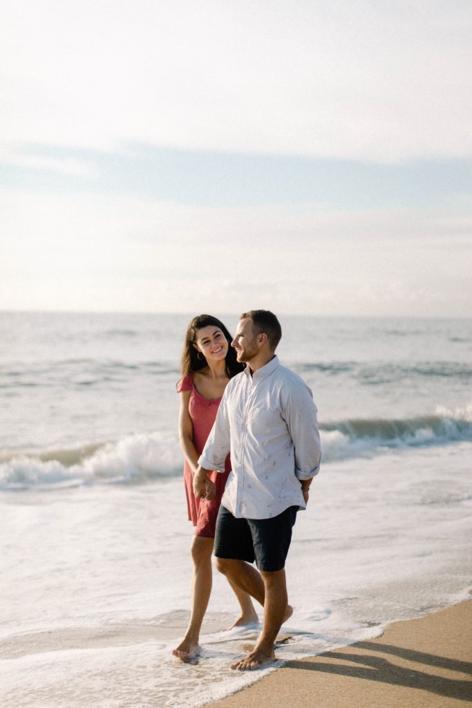 couple walking happily by the ocean 